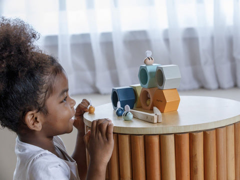 Kiddo Joy Beehives by PlanToys, an eco-friendly toy designed to enhance cognitive skills, problem-solving, and fine motor skills with fun, interactive beehive play pieces.